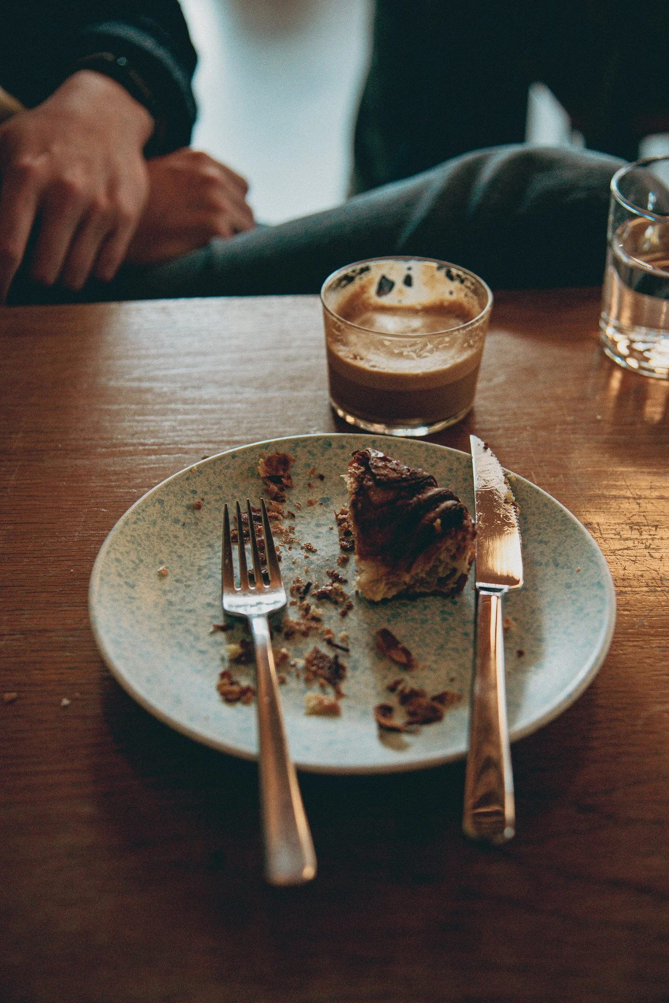 A half eaten pastry and half sipped coffee show a breakfast enjoyed