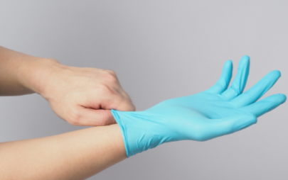 Person putting on blue disposable gloves