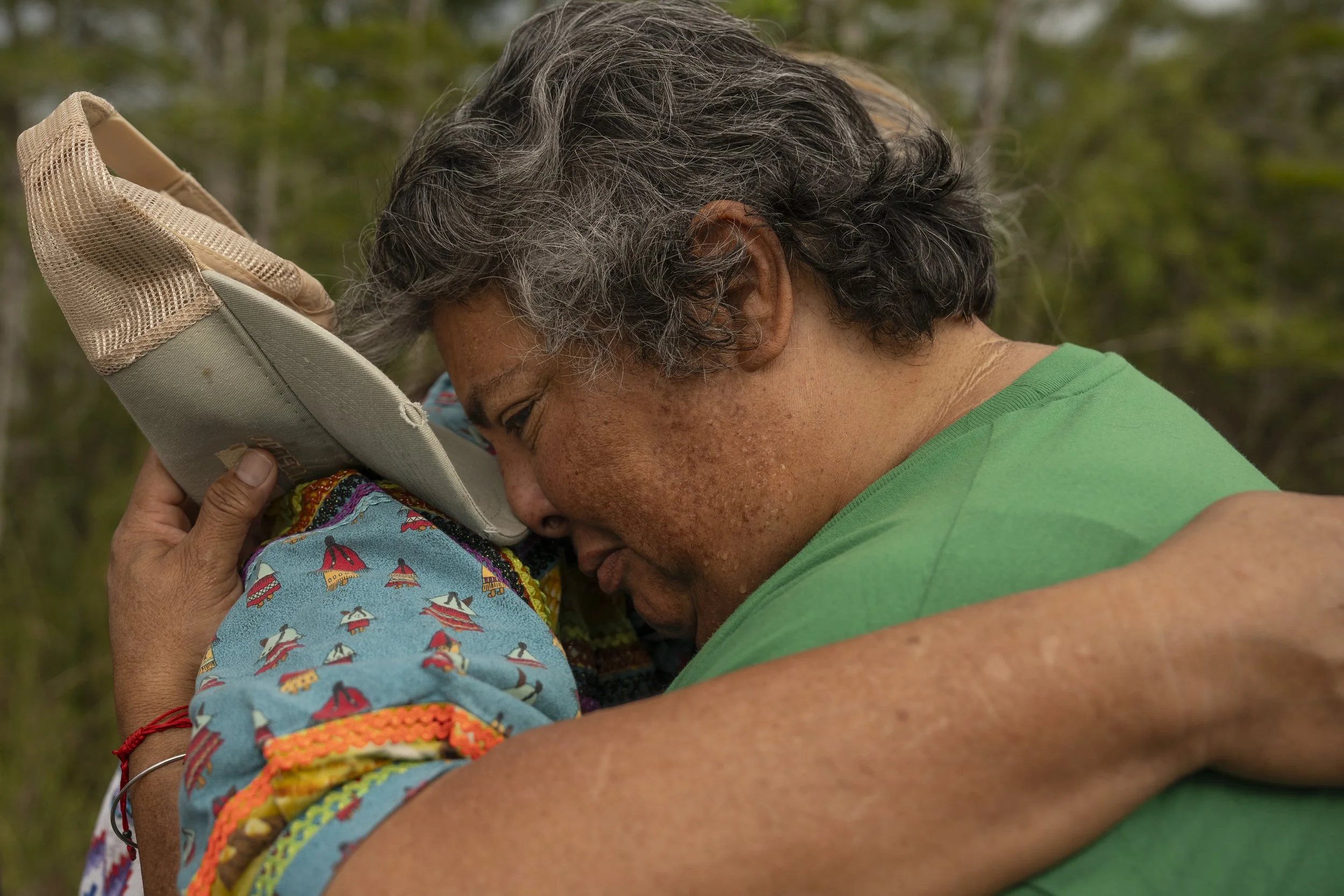 Adela Gomez cries in the arms of Betty Osceola because a family member has been detained inside Alligator Alcatraz on July 12, 2025 
