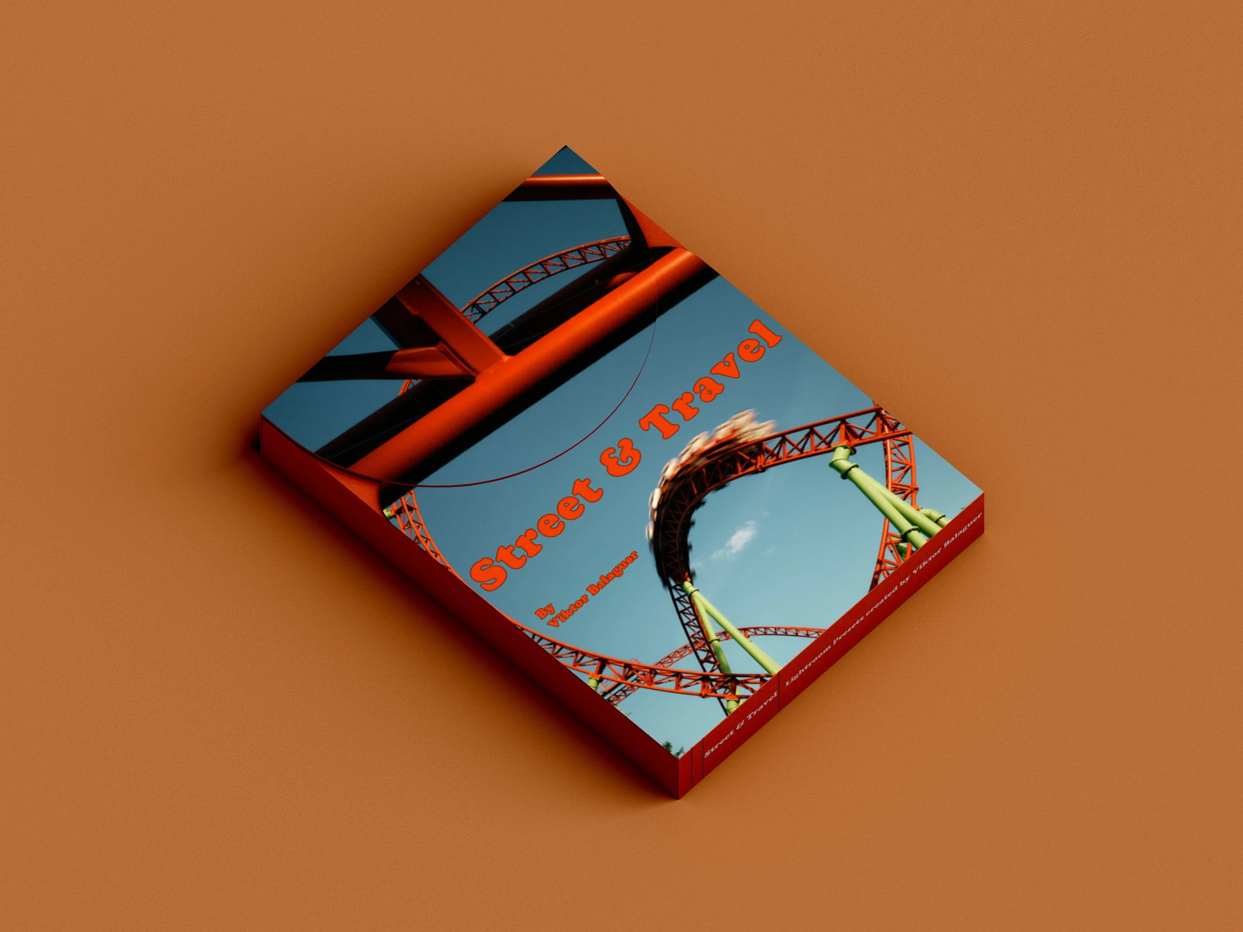 Book titled 'Street & Travel' with an image of a roller coaster on the cover, placed on an orange background.