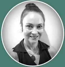 A woman with her hair in a bun smiling at the camera