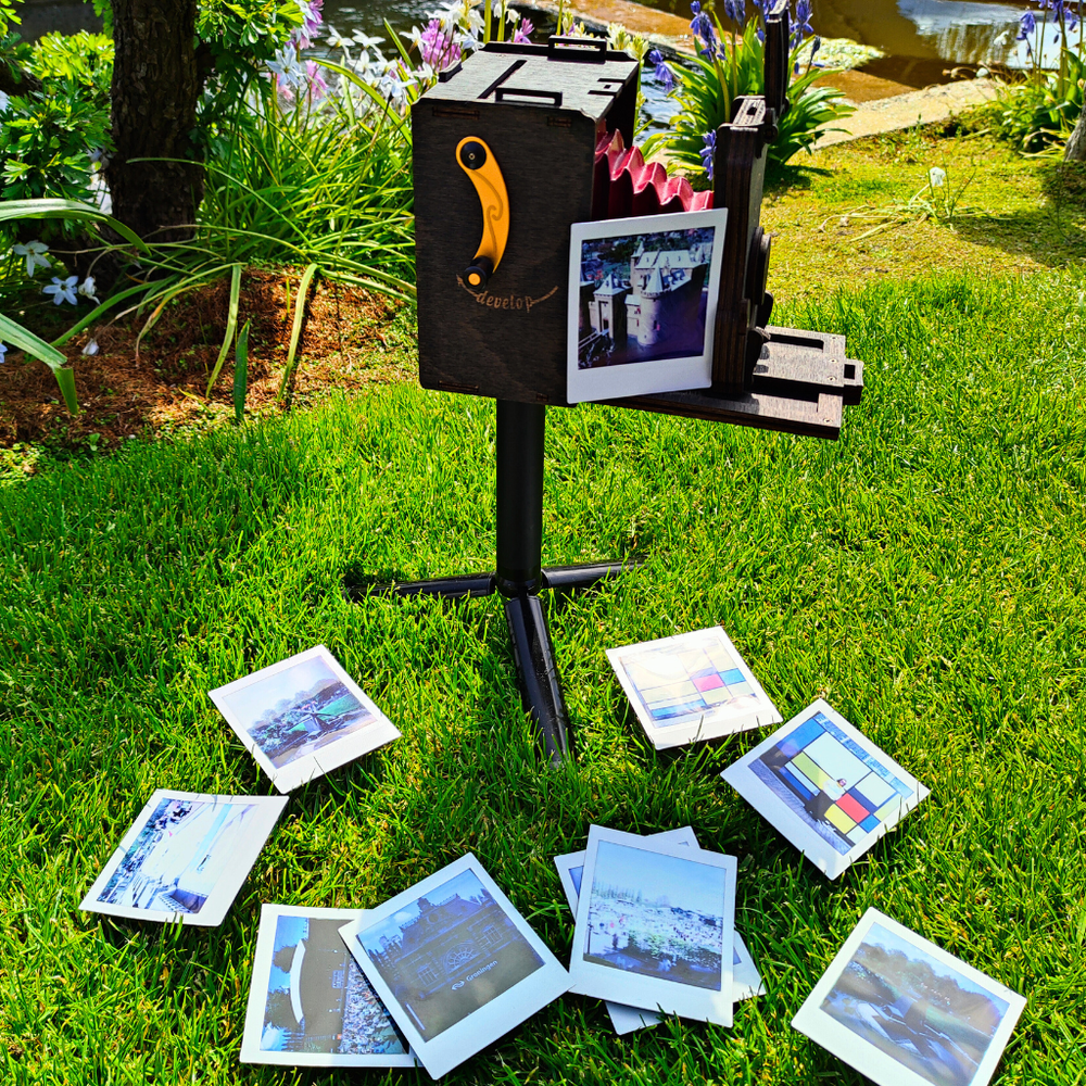 Pinhole_SQUARE_Instant_Film_Camera_on_a_tripod_positioned_on_a_green_gras.png