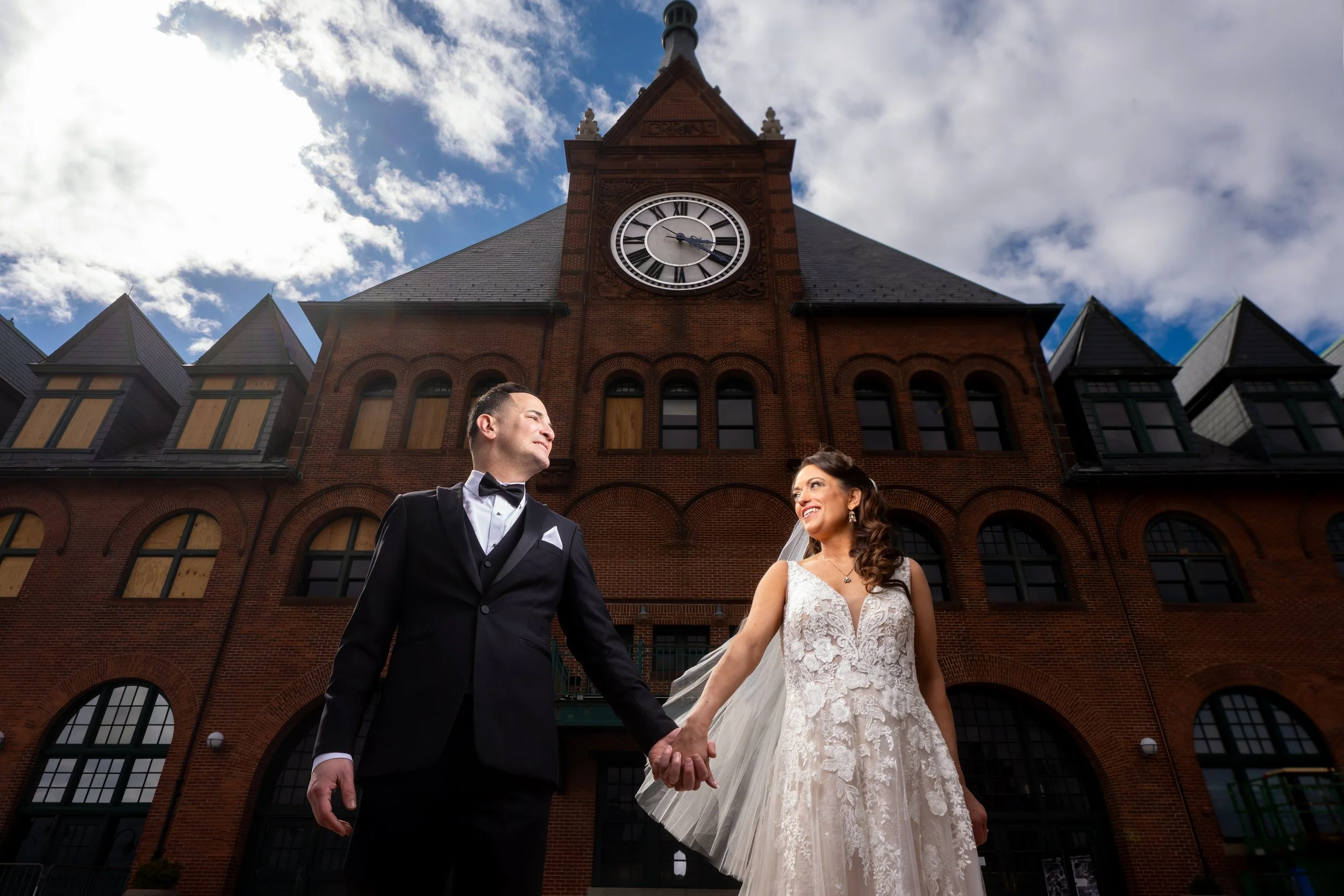"New Jersey Wedding Photographer" a bride and groom pose in front of the clock at liberty state park
