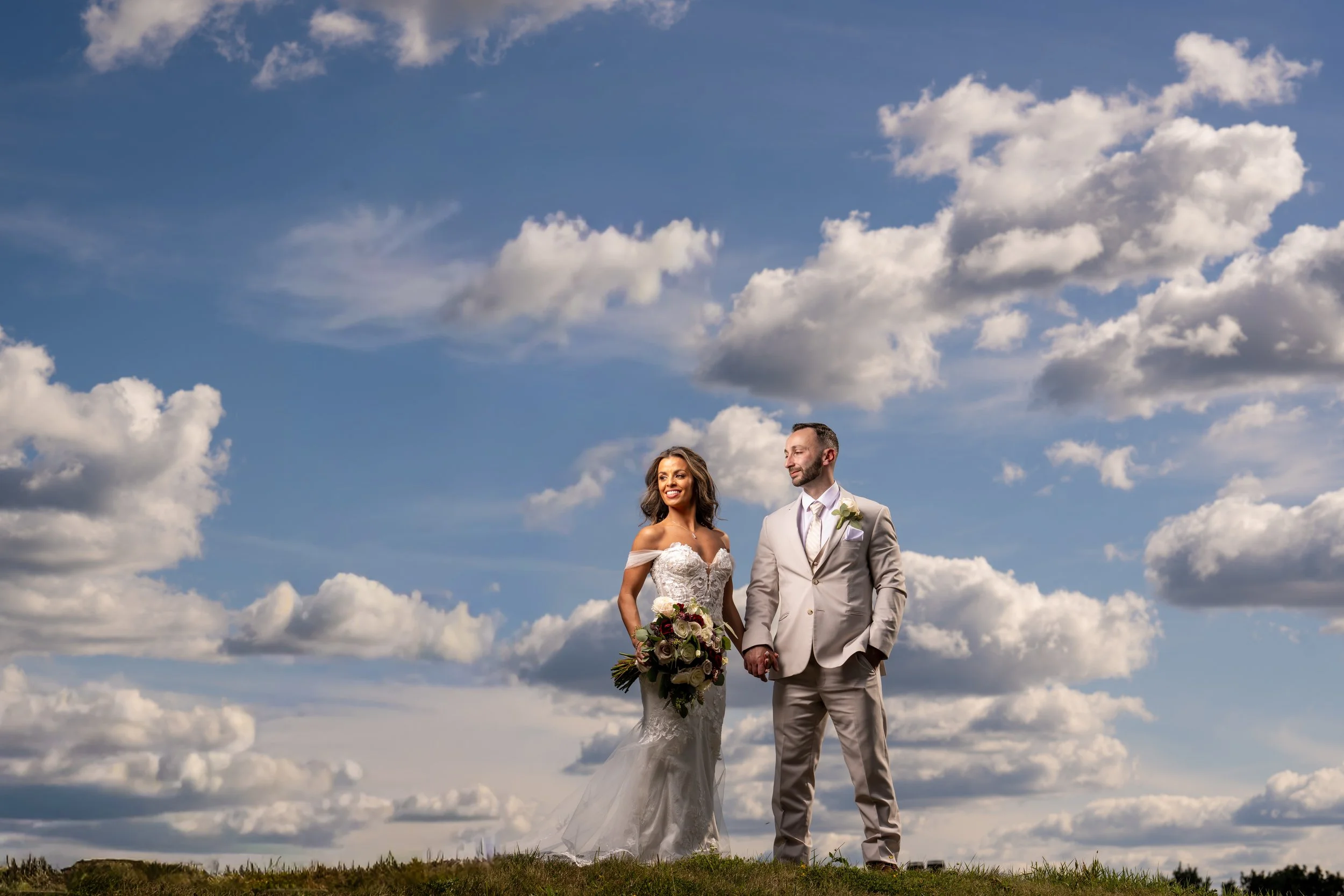 "New Jersey Wedding Photographer" a bride and groom pose in front of clouds at "Crystal Springs Resort"