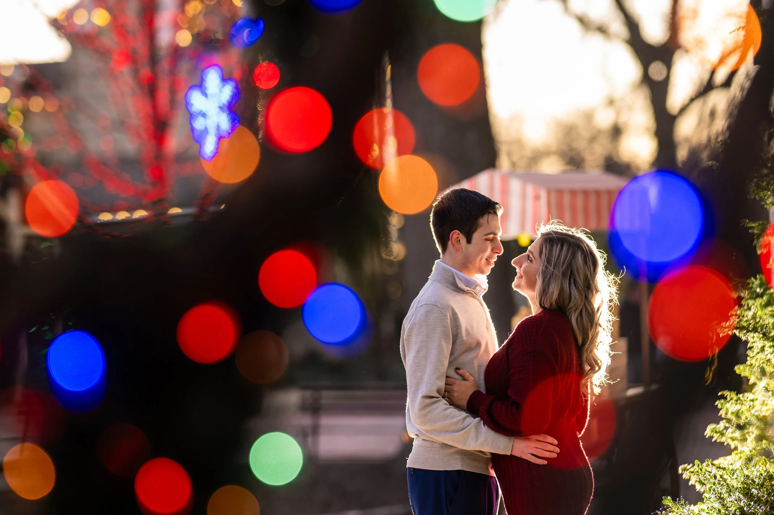 A couple standing in a downtown area with lights in the foreground
