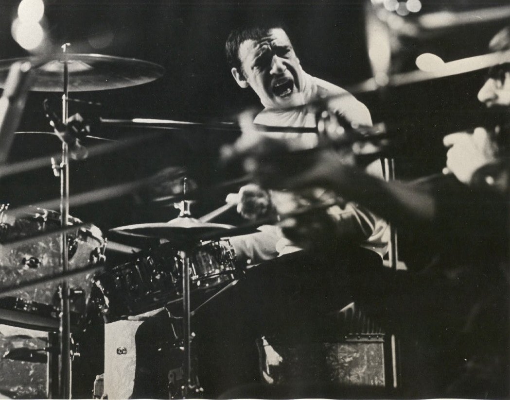 Black-and-white photo of jazz drummer Buddy Rich playing intensely behind a drum kit, captured mid-performance.