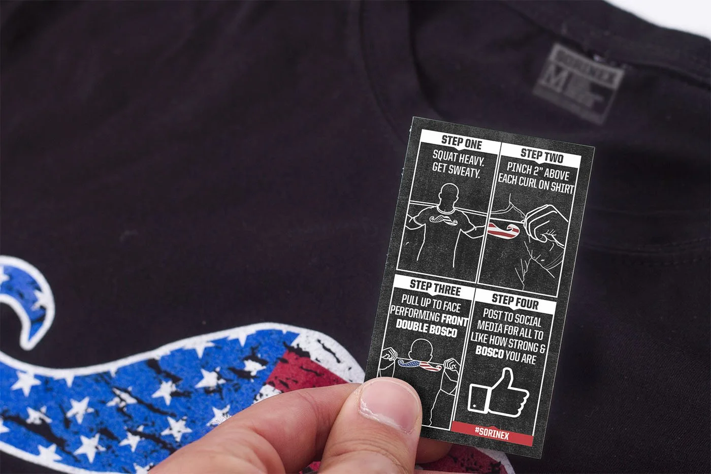 A person holding instruction card with four steps. Step one: squats heavy, get sweaty. Step two: pinch 2 inches above each curl on shirt. Step three: pull up to face performing front double bosco. Step four: post to social media to show strength and bosco. The card has illustrations depicting each step.