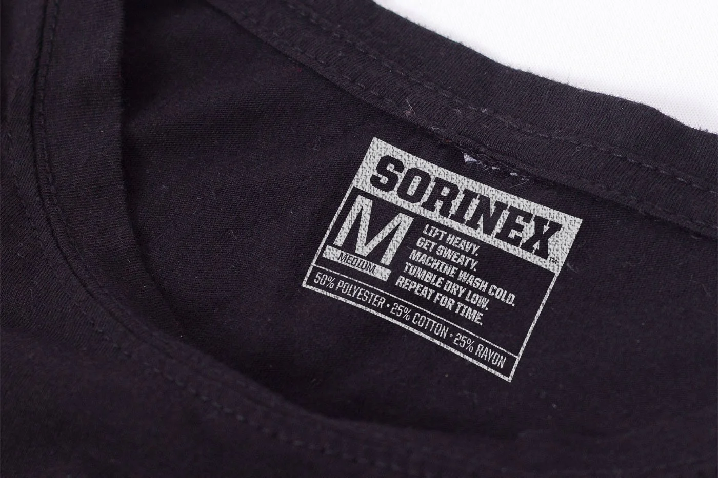 Close-up of clothing label on a black shirt, showing brand name 'SORINEX', size medium, and washing instructions.