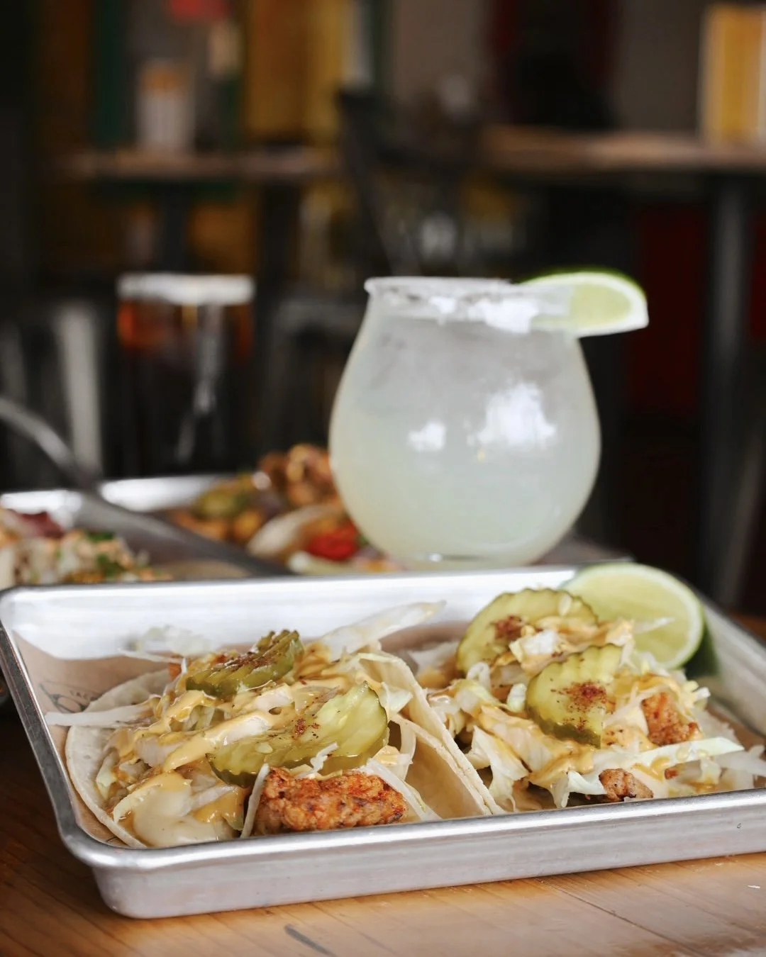 Hot honey chicken taco, mike's hot honey, queso blanco, shredded lettuce, and dill pickles.