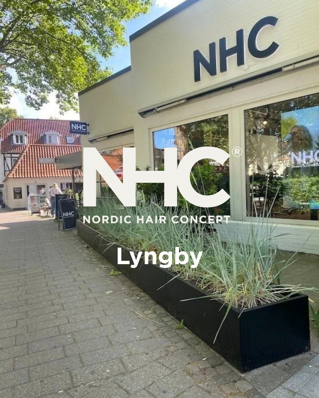 Nordic Hair Concept Lyngby. Udendørsfoto af en bygning med NHC logo, der står for Nordic Hair Concept, på en tilfældig dag.