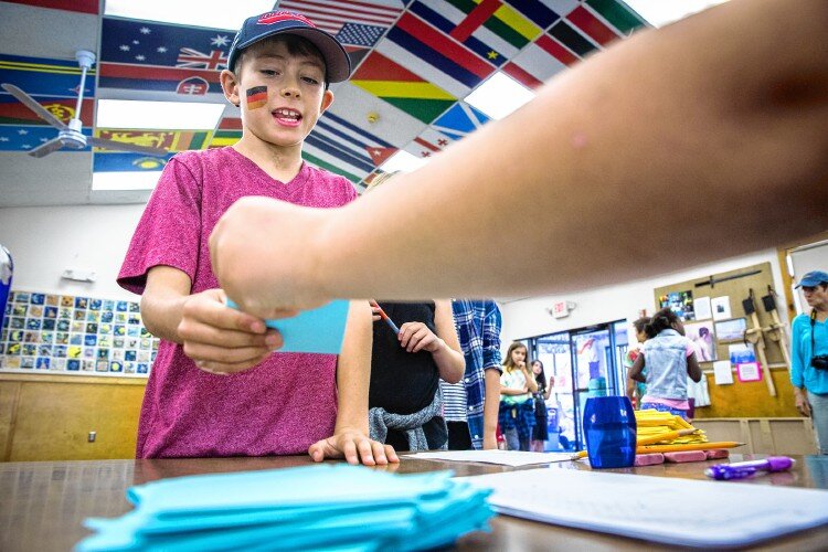  Nico Fasulo, a fifth grade student at the Center School in Greenfield checks in at the polls during their school's mock election Tuesday, October 18.  