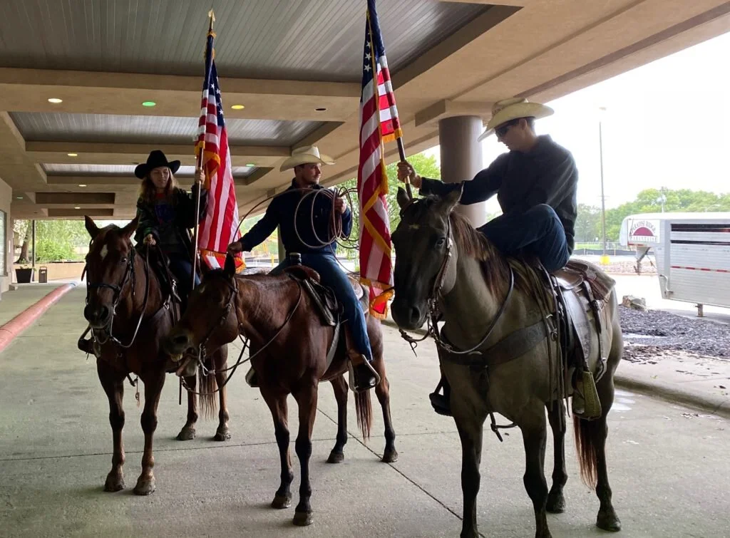 Ranchers Nicole Pfrang, Tyler Heiman, and Tyler Herrman road into the rally on horseback. Photo courtesy of Angela Huffman.