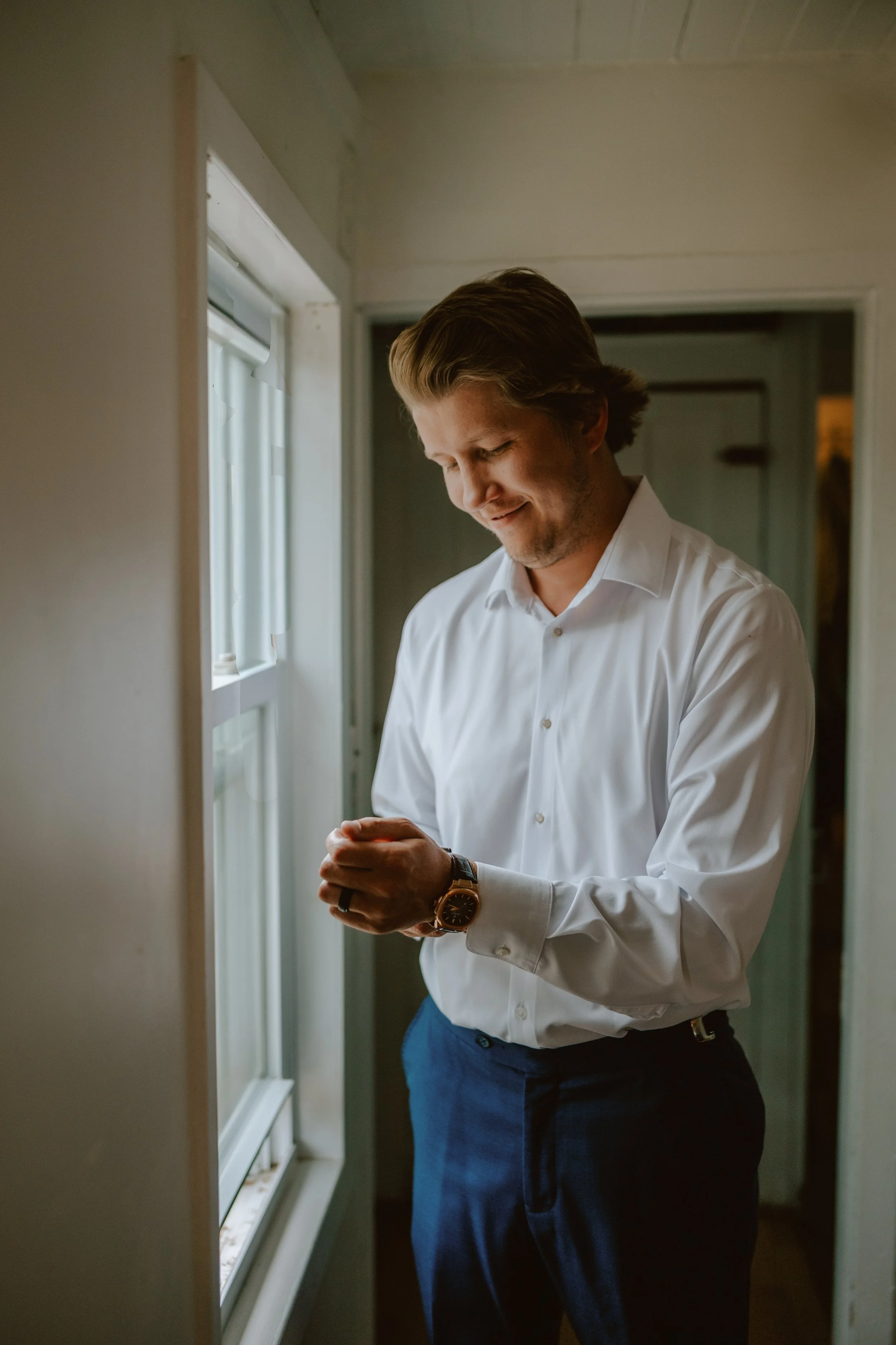 Groom Getting Ready in Window Light.jpg