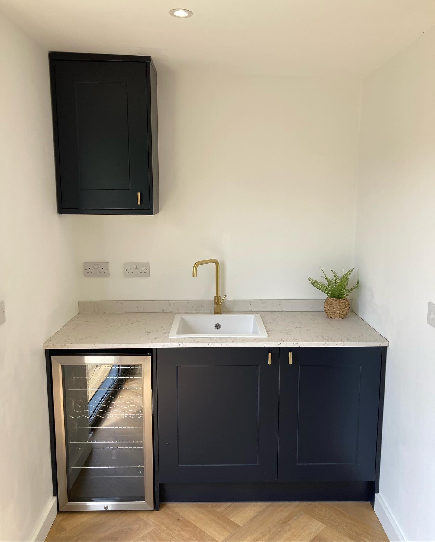 Matt navy kitchen area with marble worktop, brushed gold tap, gold knurled handles and under counter drinks fridge. Looking crisp and ready for use 👌