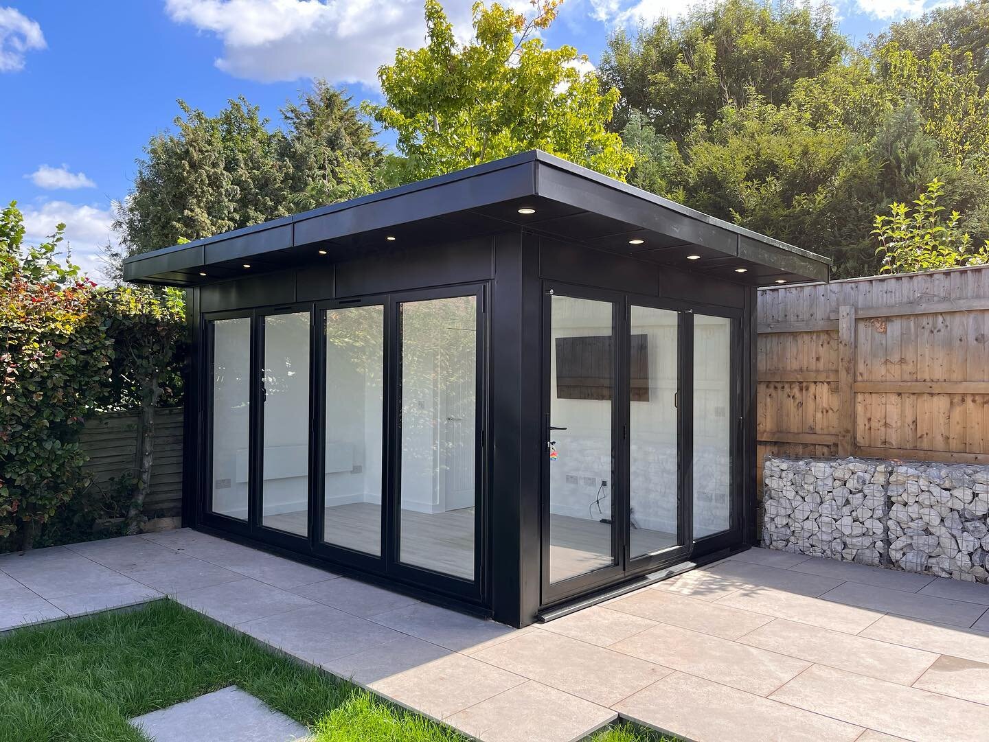 Nordic night black metal clad garden room with dual sets of bi-folding doors to create an inside/outside space that sits perfectly in the landscape. Fully insulated with positive ventilation system and w/c to make the space multi functional and usabl