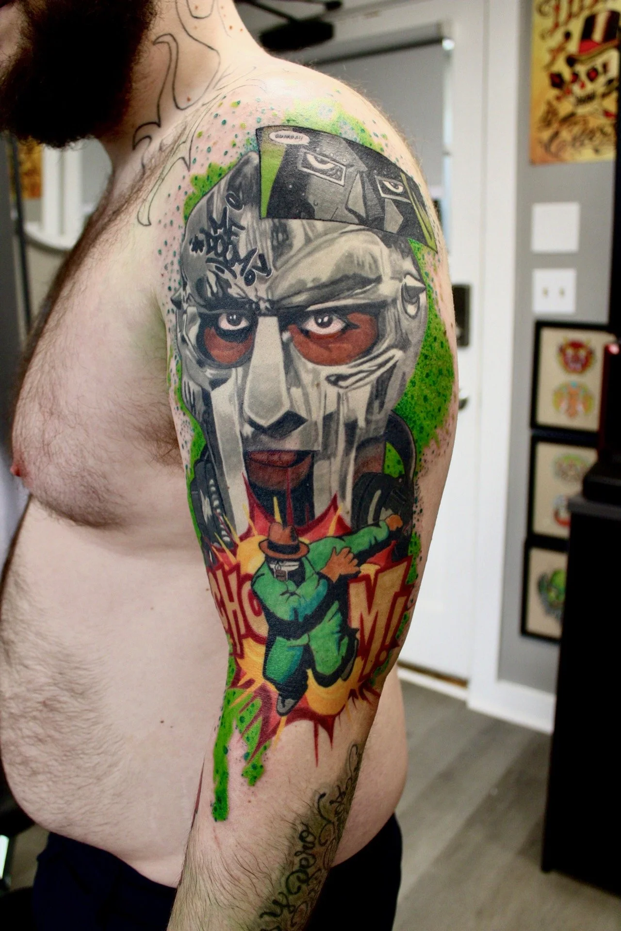 Color masked comic character tattoo by Damian Marinelli