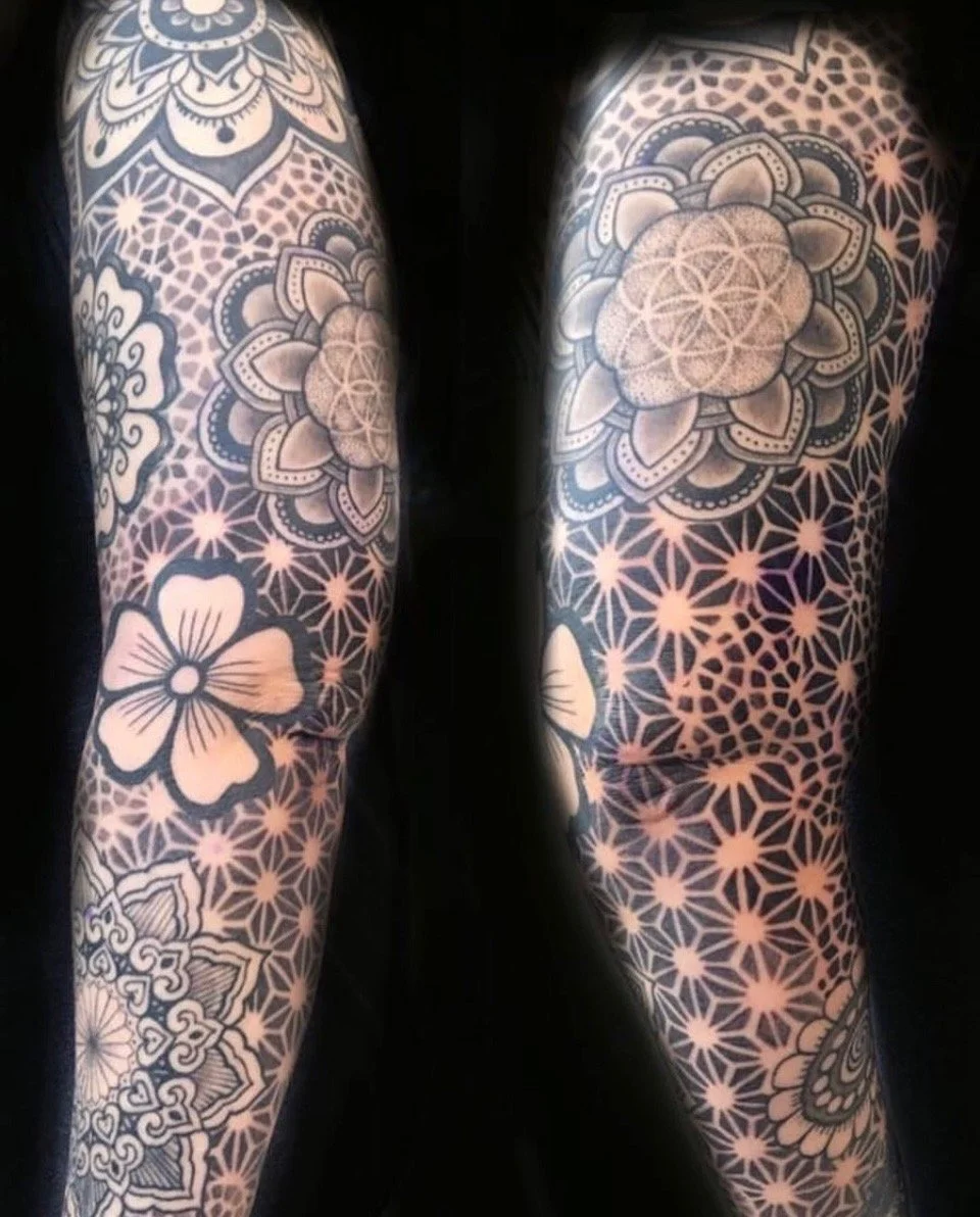 Black-and-grey geometric mandala sleeve tattoo by Anna Small