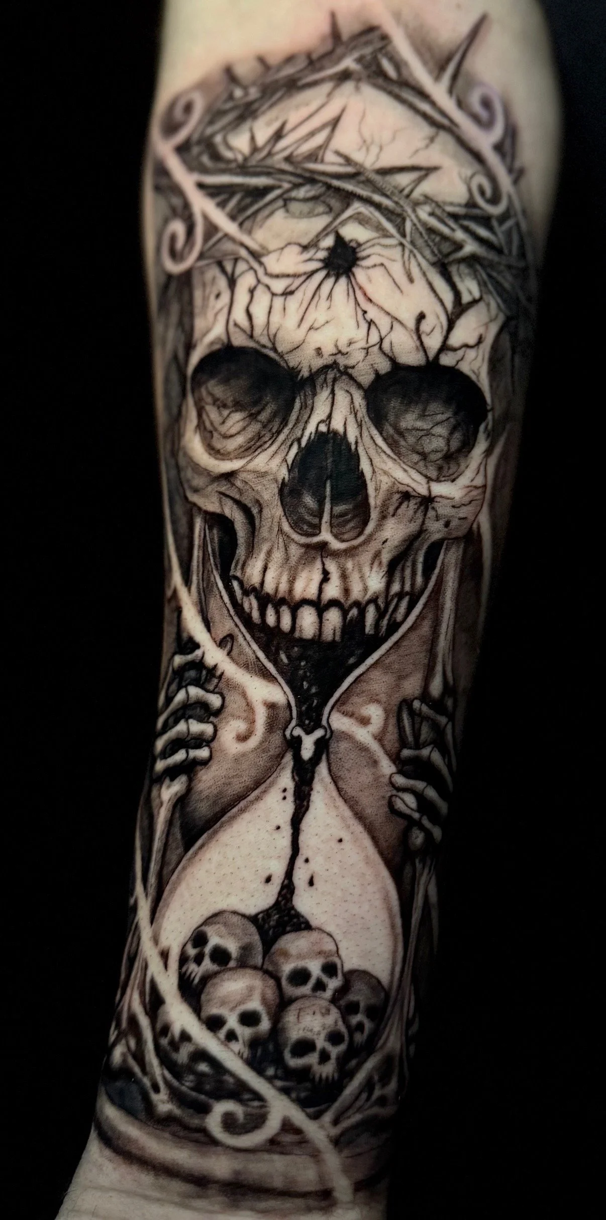 Black-and-grey skull and hourglass tattoo by Damian Marinelli