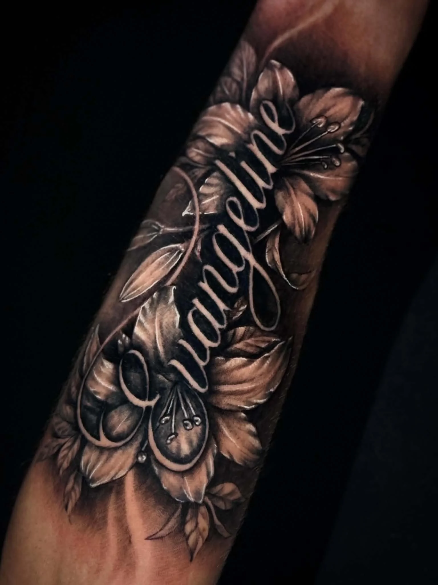 Black-and-grey flowers and script tattoo by Hailee Rivera