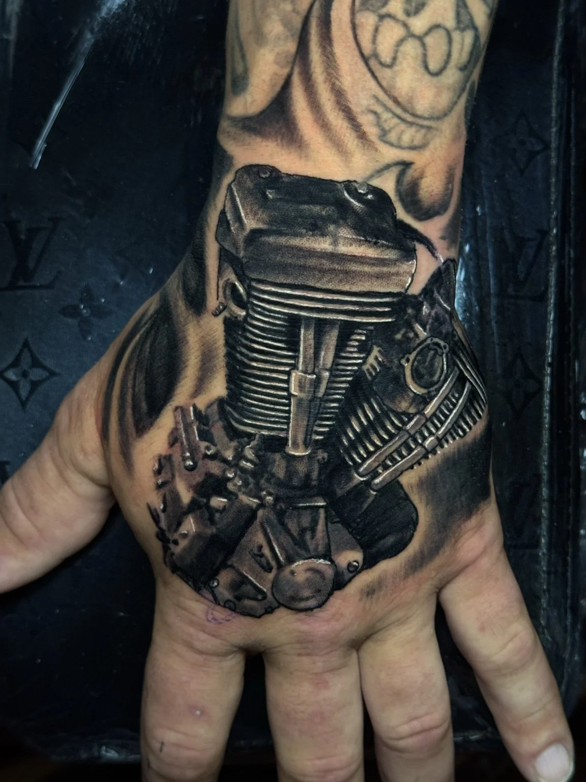 Realistic black-and-grey engine hand tattoo by Scott Flanders