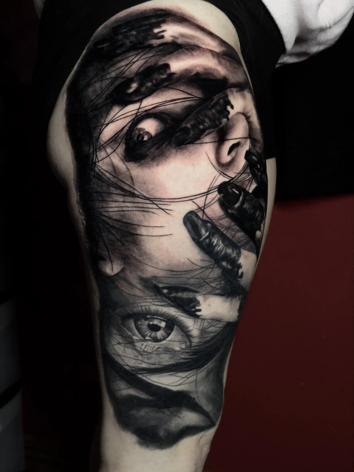 Surreal black-and-grey portrait upper-arm tattoo by Scott Flanders