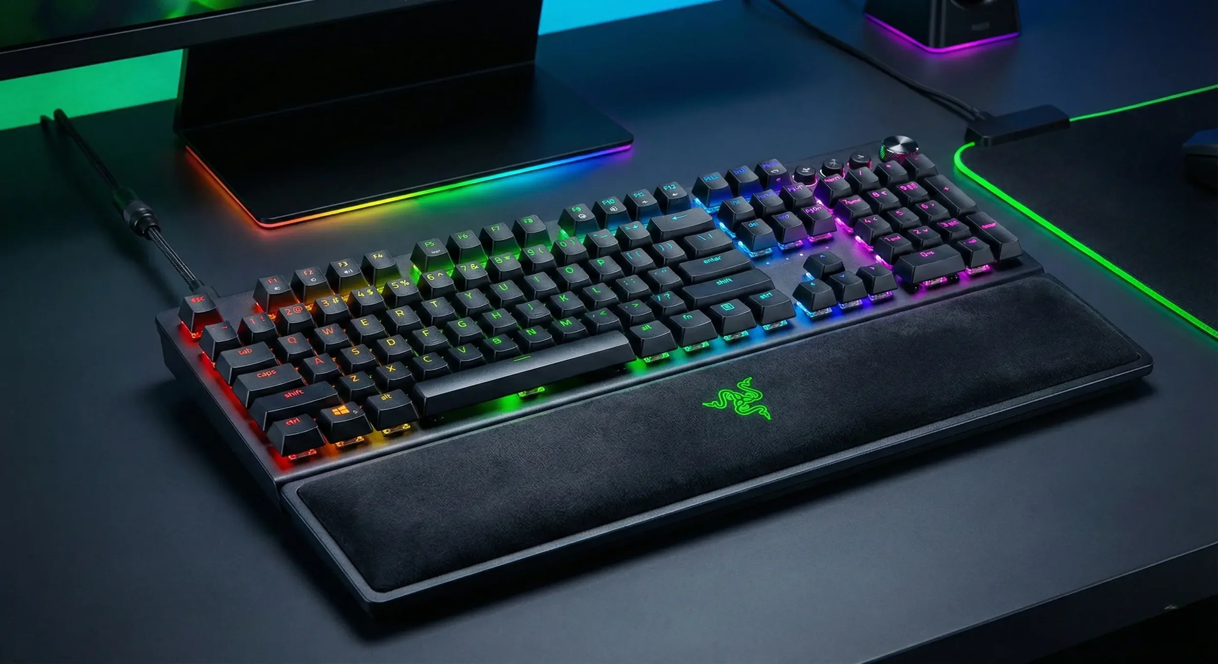A detailed screenshot from the game Mechanical vs. Membrane Keyboards showing a black, full-sized gaming keyboard with RGB backlighting, complete with a detachable wrist rest bearing the Razer logo.