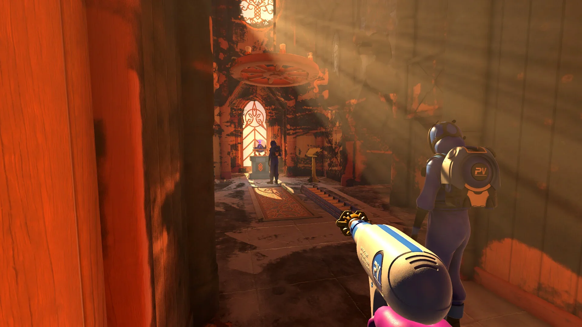 A screenshot from PowerWash Simulator 2 showing the player in a dusty, dilapidated temple, holding the power washer. A co-op partner stands nearby as sunlight highlights the contrast between the grime and a cleaned patch of bright orange wood.