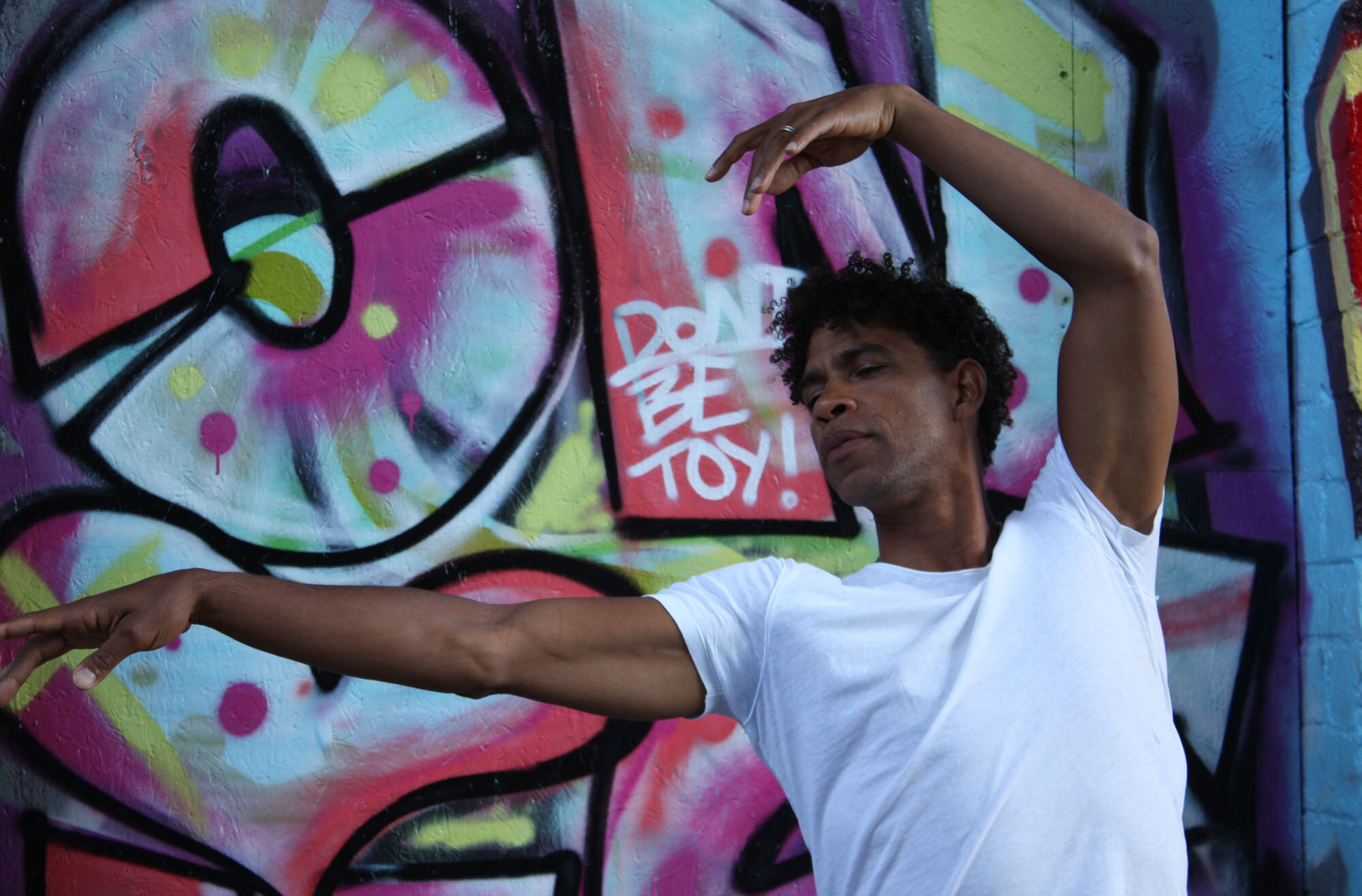 Ballet dancer Carlos Acosta dancing in front of graffiti for the final commission of Sky Arts Portrait Artist of the Year 2020 by Curtis Holder