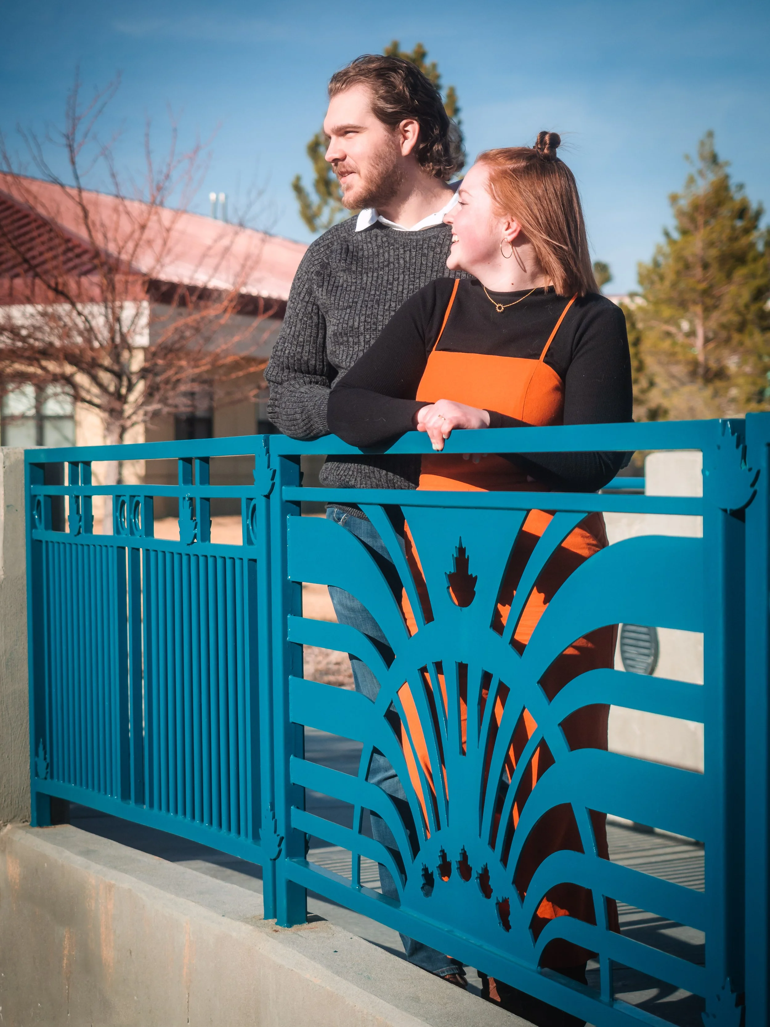 Couple on a bridge during their engagement photos.
