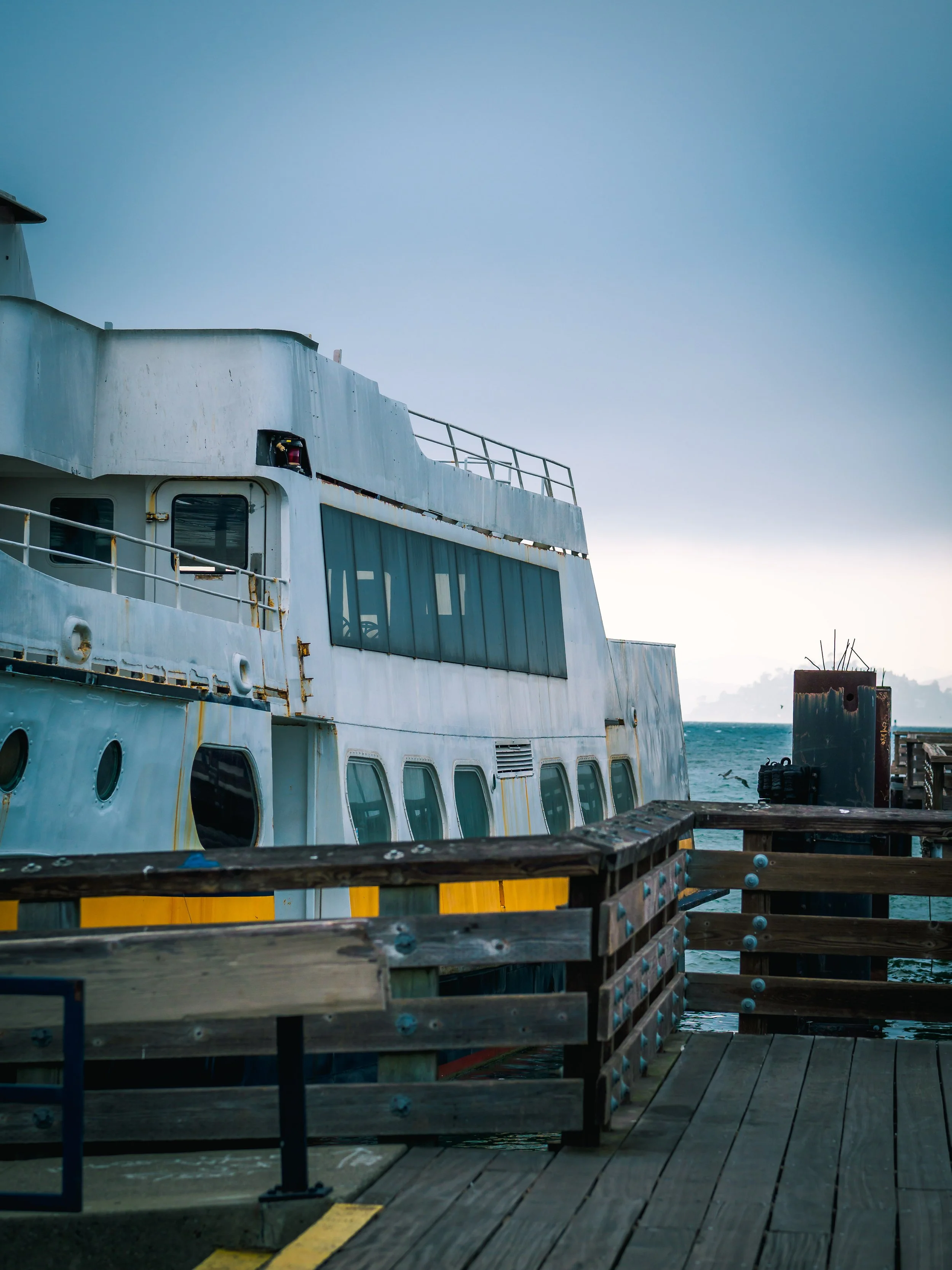 A boat or ferry in the dock with the ocean and Alcatraz in the background at Fishermans Wharf in San Francisco California