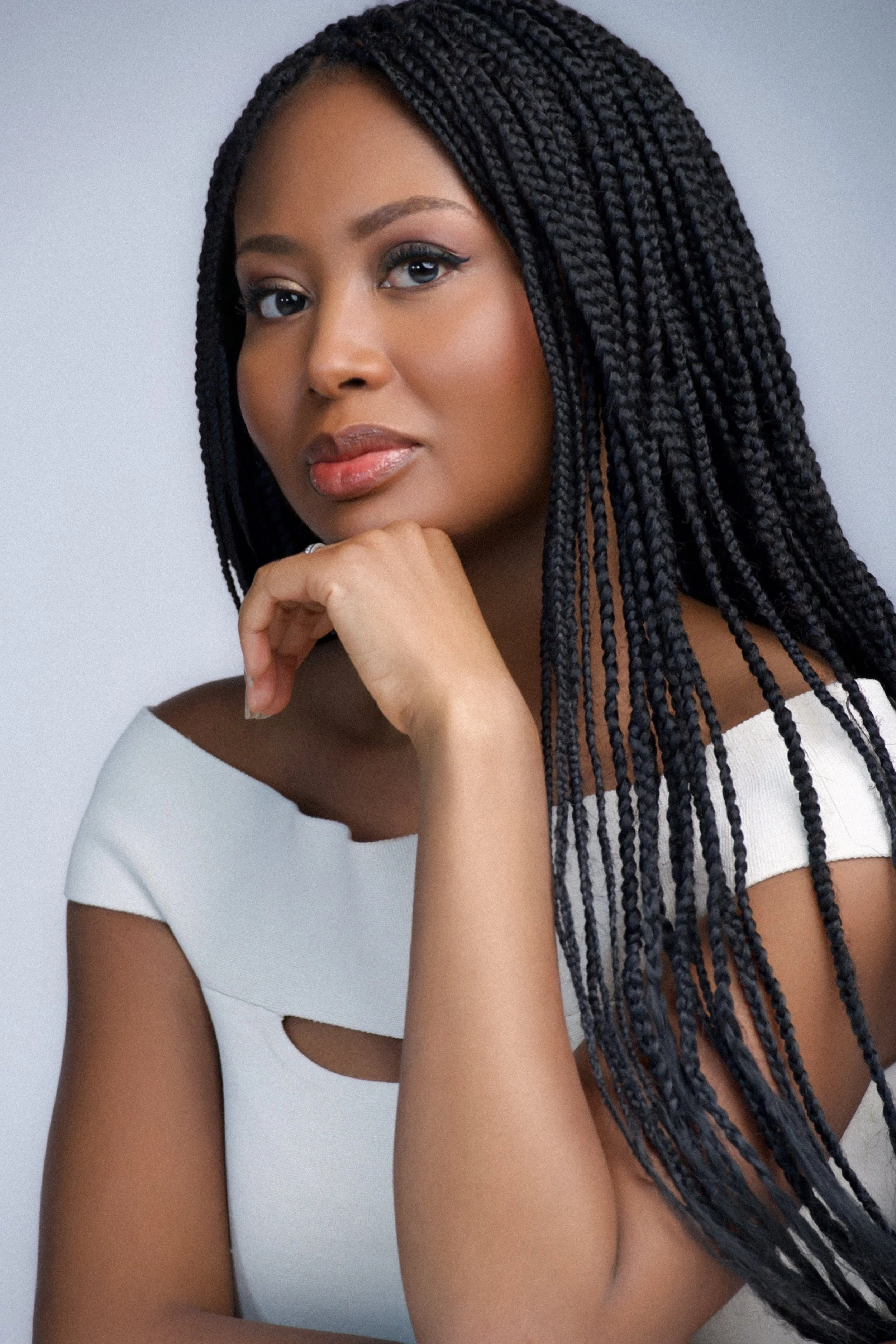 Delali Adjoa sitting in front of a gray background.