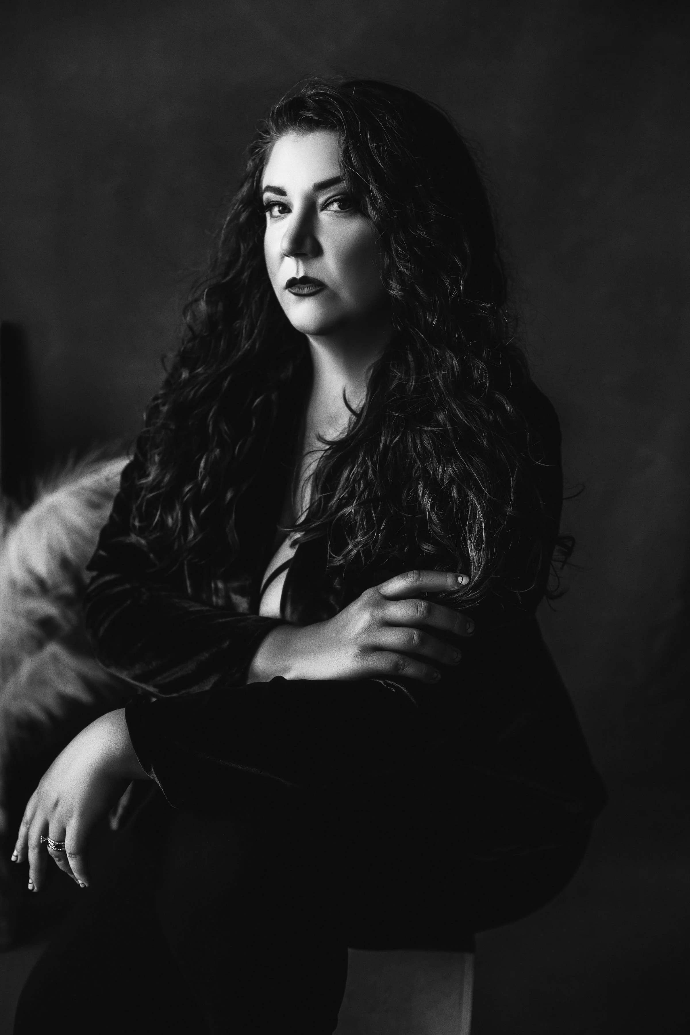 Kristi DeMeester sitting down and crossing her right arm over her left arm.