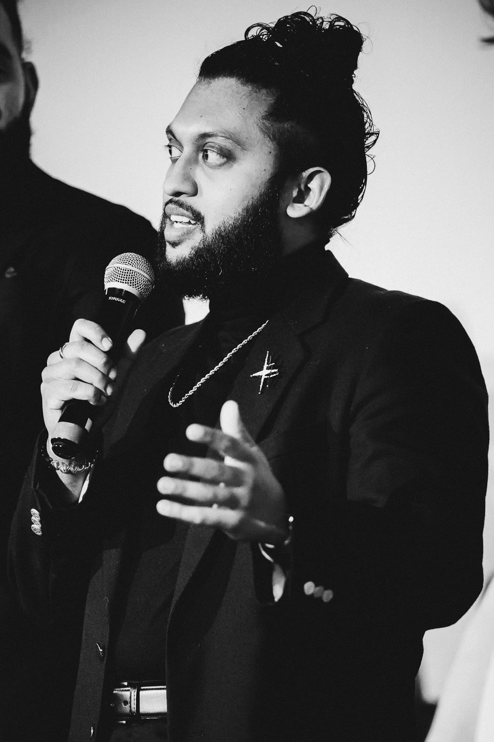 Abijeet Achar talking into a black microphone