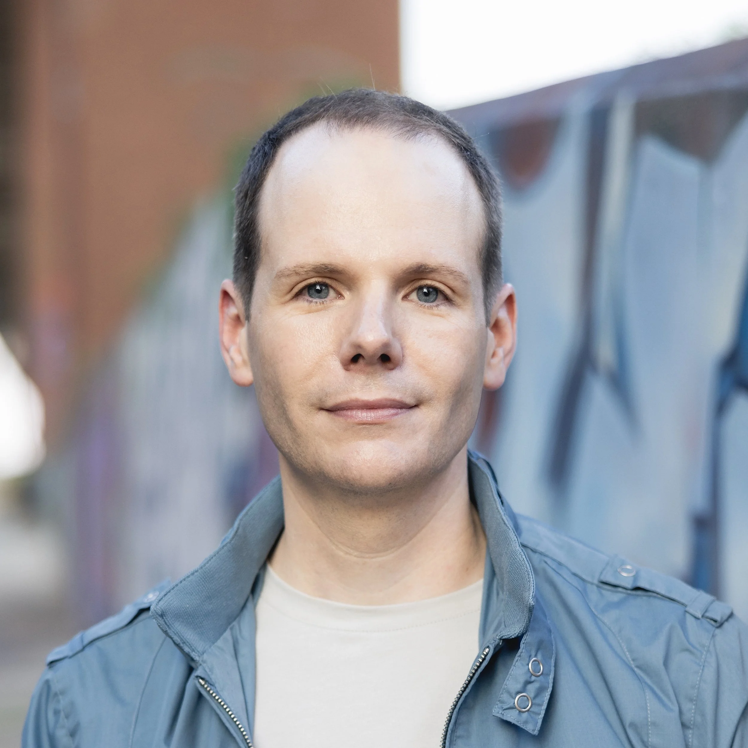 Cory Albertson standing in front of a brown and blue wall.