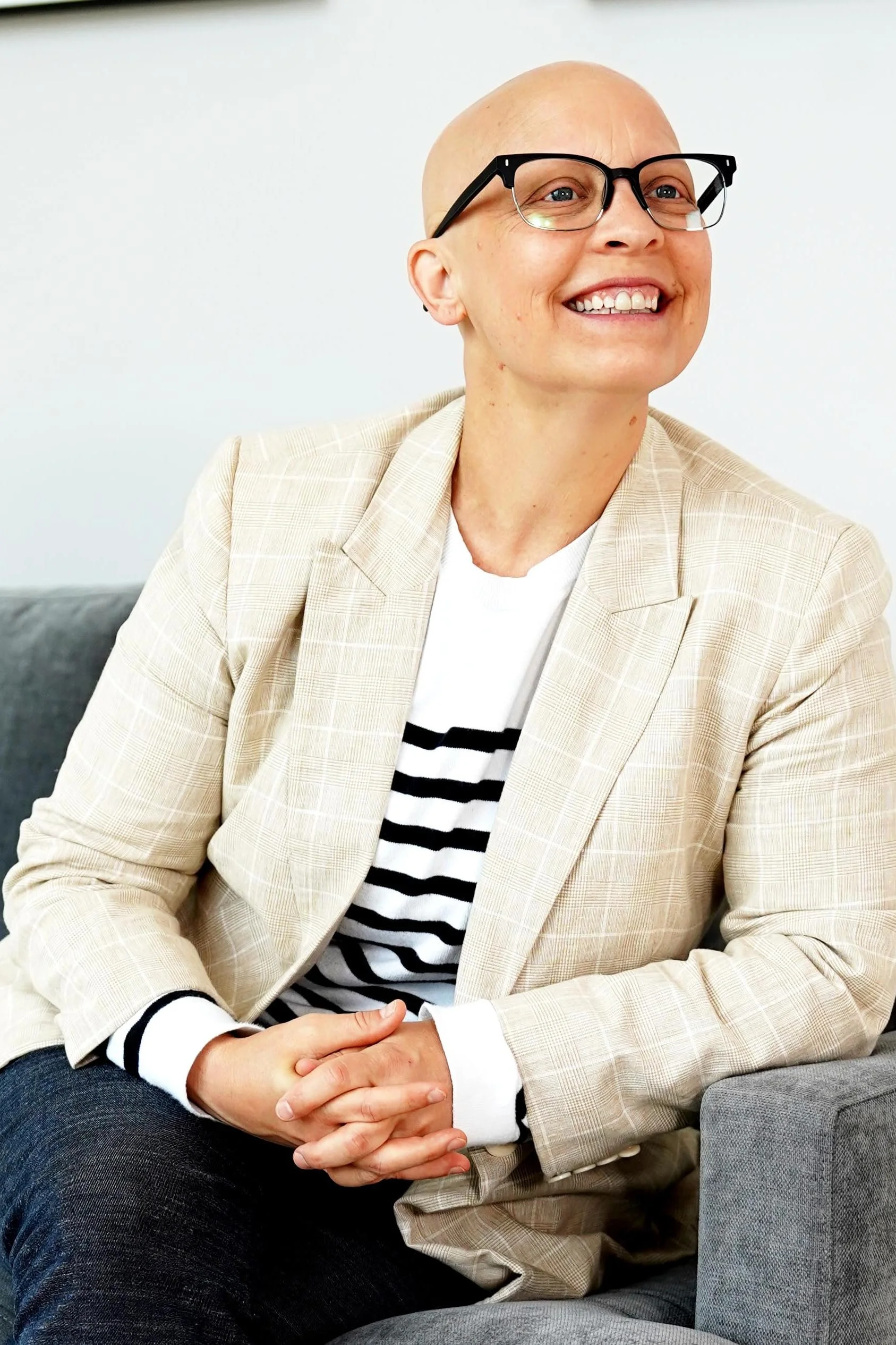 Charlene Fisk sitting on a gray couch.