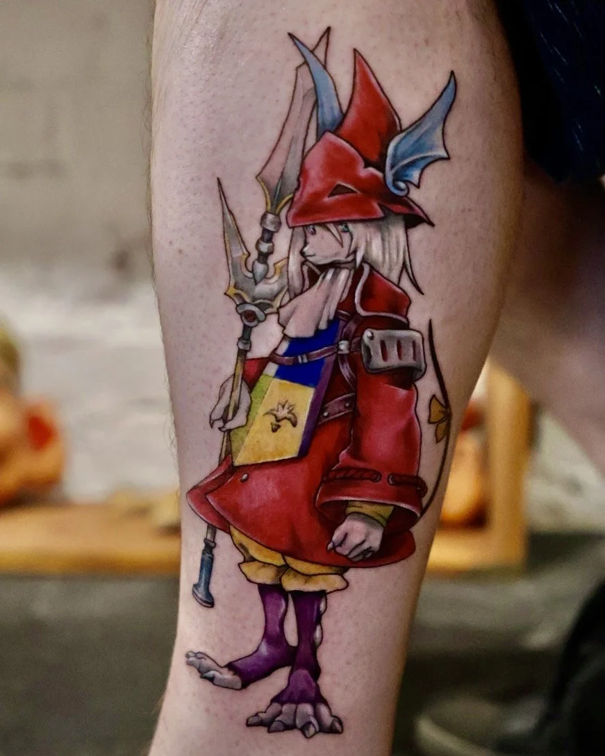 Tattoo of a fantasy creature with a bird-like beak, wolf-like paws, wearing a red cloak and hat, holding a staff, and carrying a colorful shield.