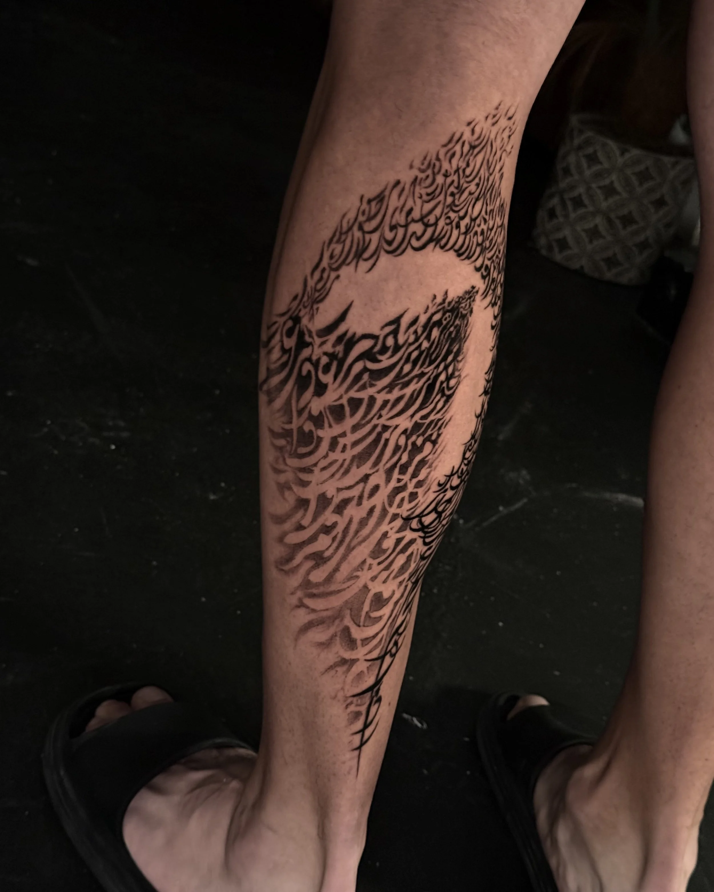 A tattoo of a tree with branches and roots on a person's lower leg.
