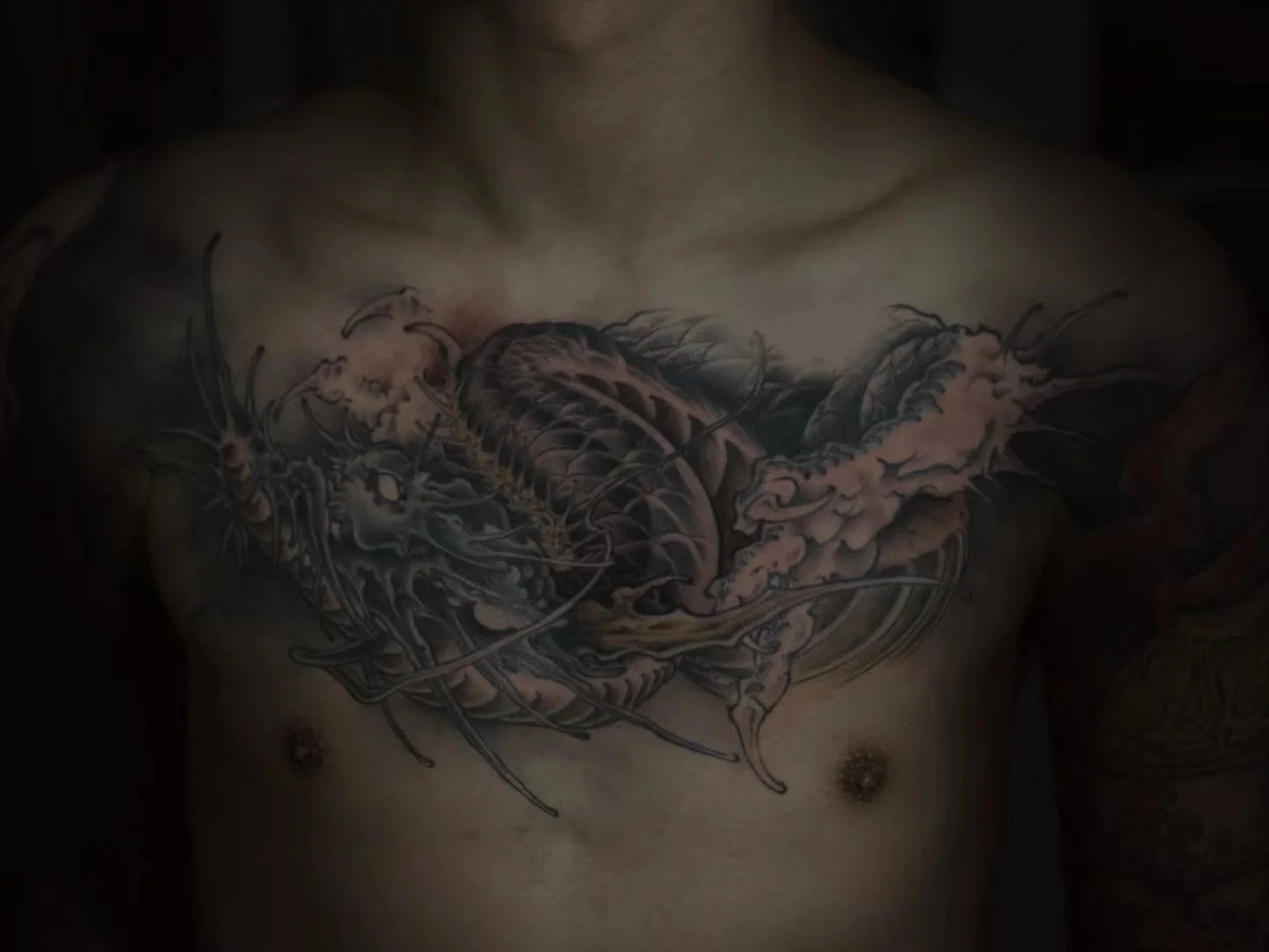 Tattoo of a barnacle and lobster on person's chest