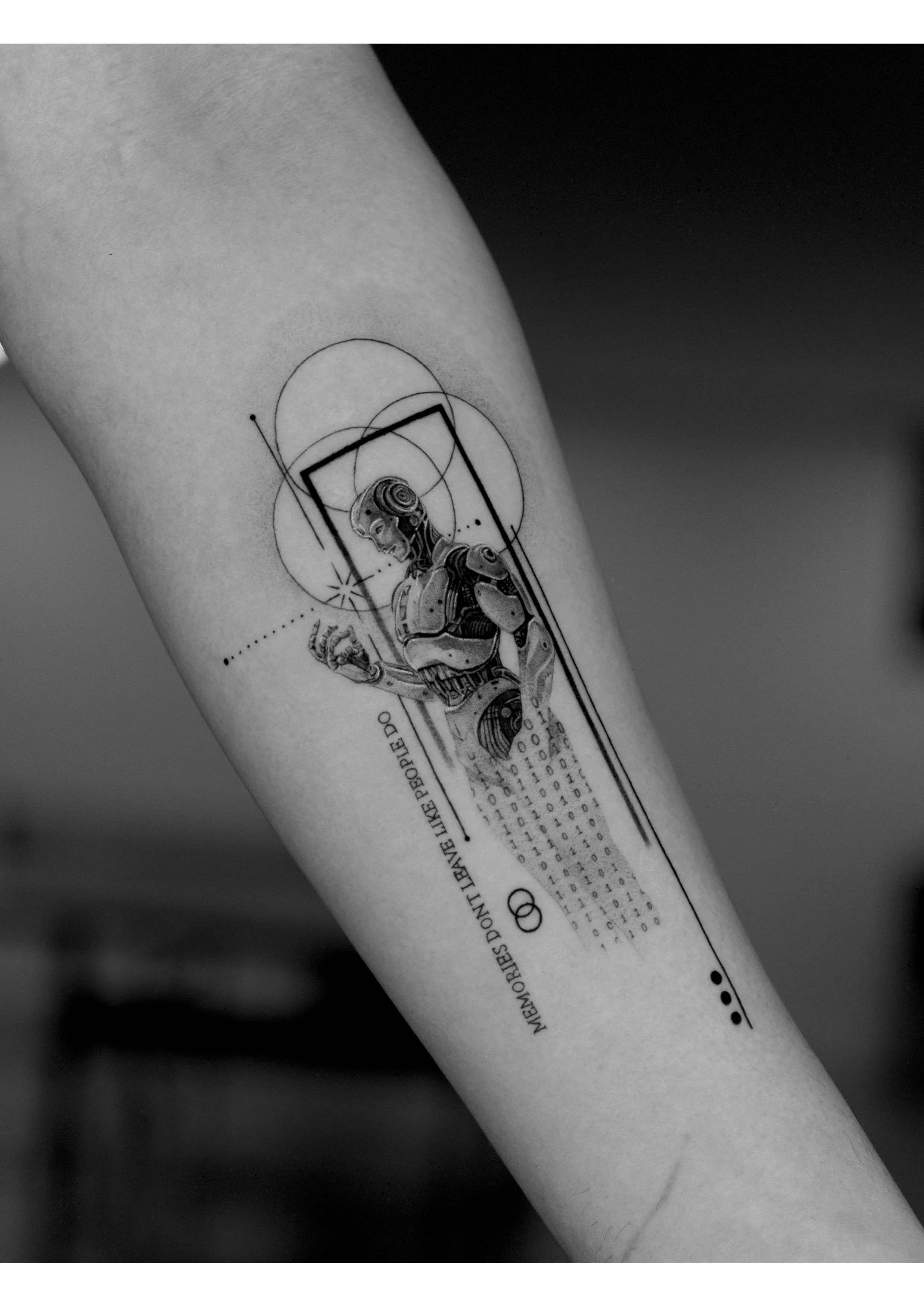 Tattoo of a futuristic humanoid robot in a geometric, digital art style on a person's arm.