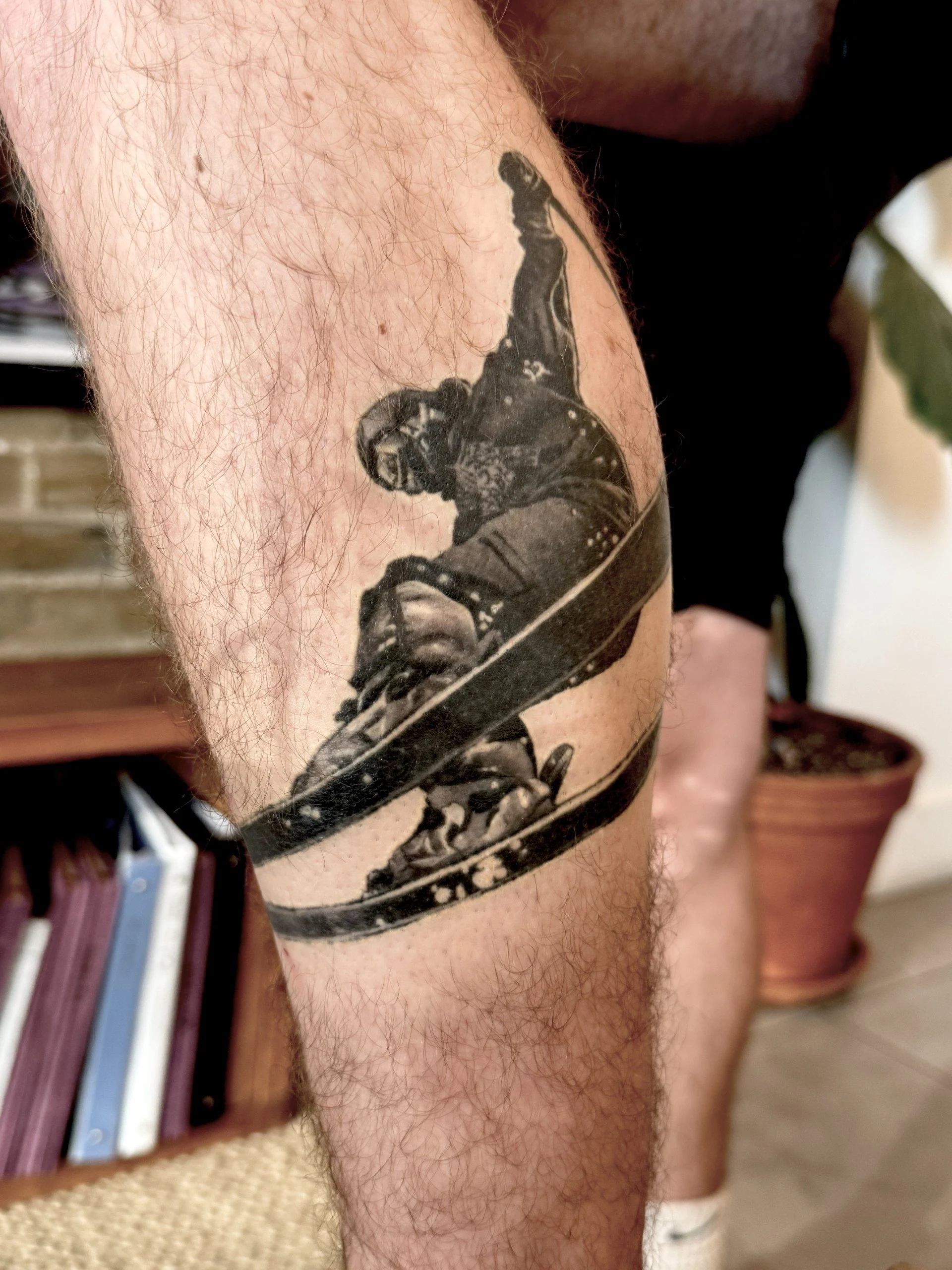 Tattoo of a skateboarder performing an ollie on the thigh.