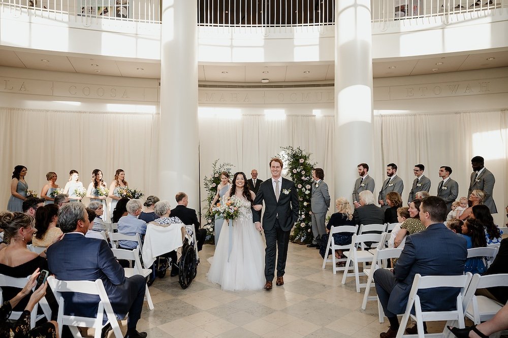 formal wedding ceremony inside the fernbank museum of natural history in atlanta ga