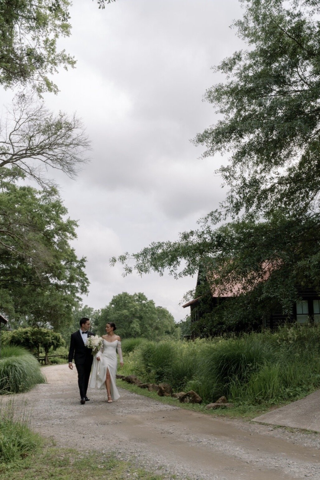 bride and groom walking through the inn at serenbe gardens on wedding day