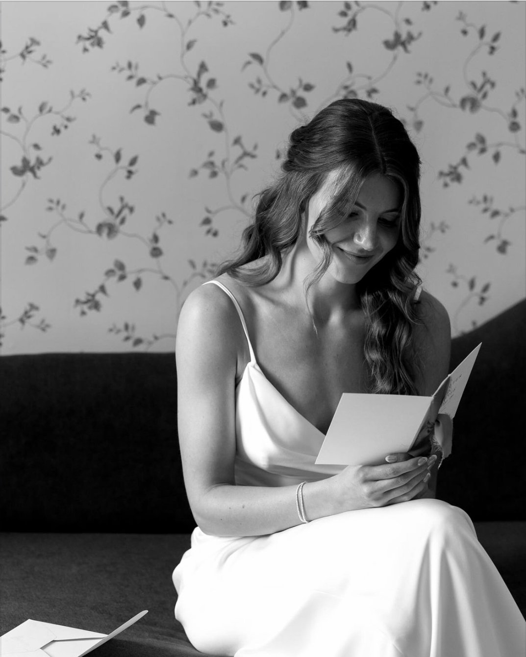 bride reads a letter from the groom in the bridal suite at hills and dales estate
