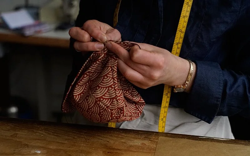 Kate hand finishing an Alleyhats cycle cap