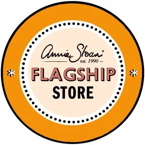 Logo for Annie Sloan Flagship Store with a circular design, orange outer ring, white background, and black and red text.