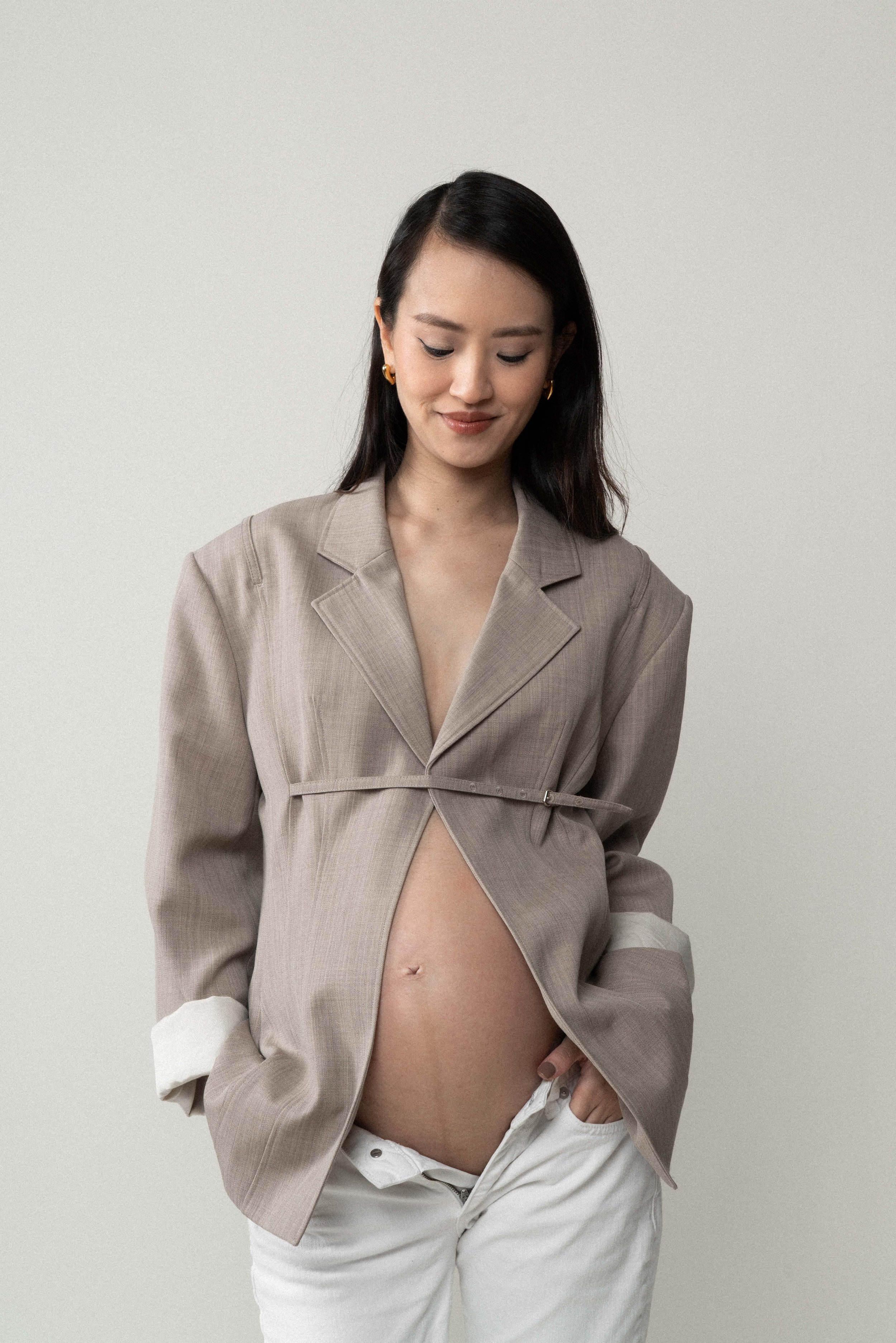 Quiet detail shot — Christina dressed in a blazer in soft studio light
