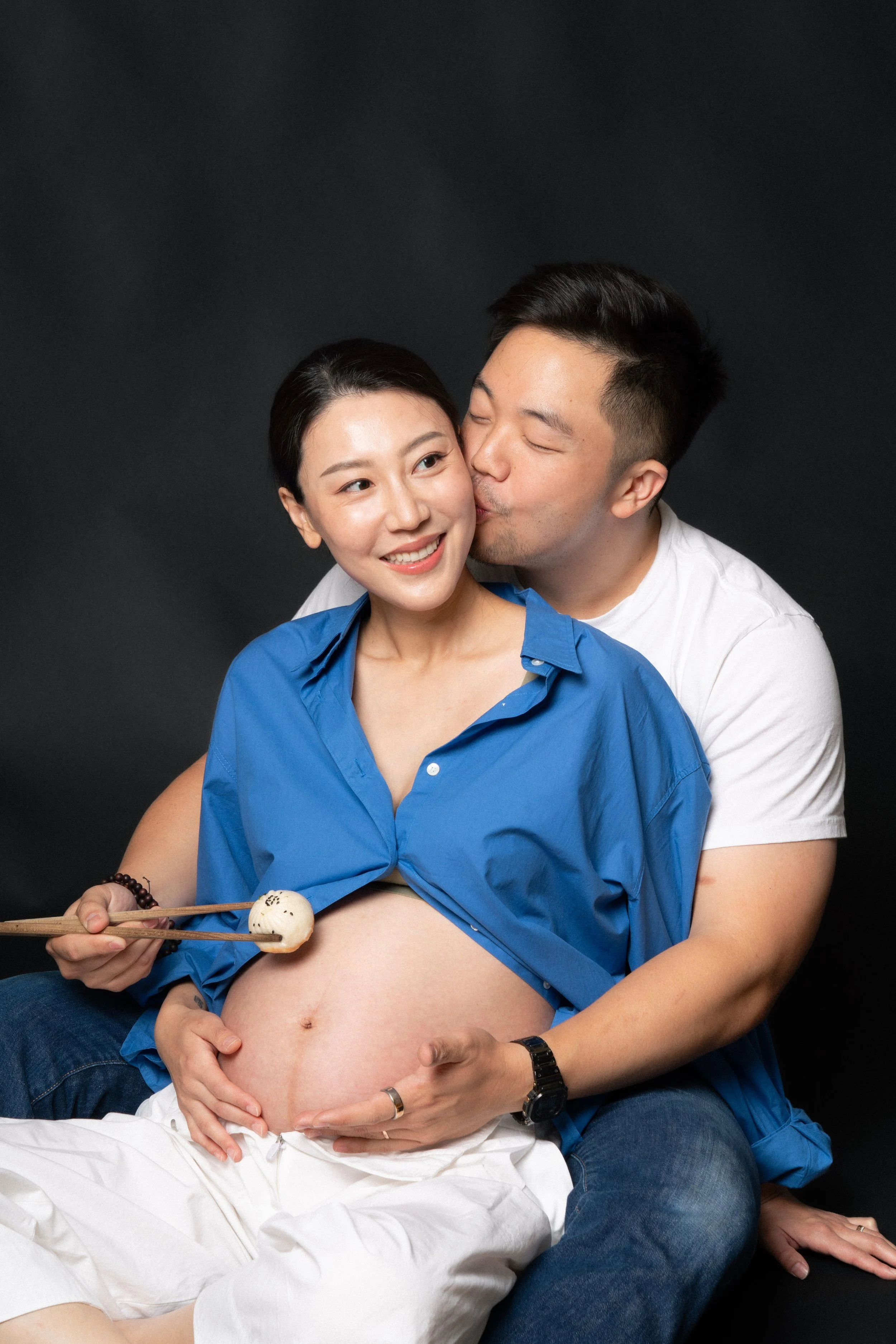 Cloris and Eric embracing, with Eric feeding the baby a dumpling