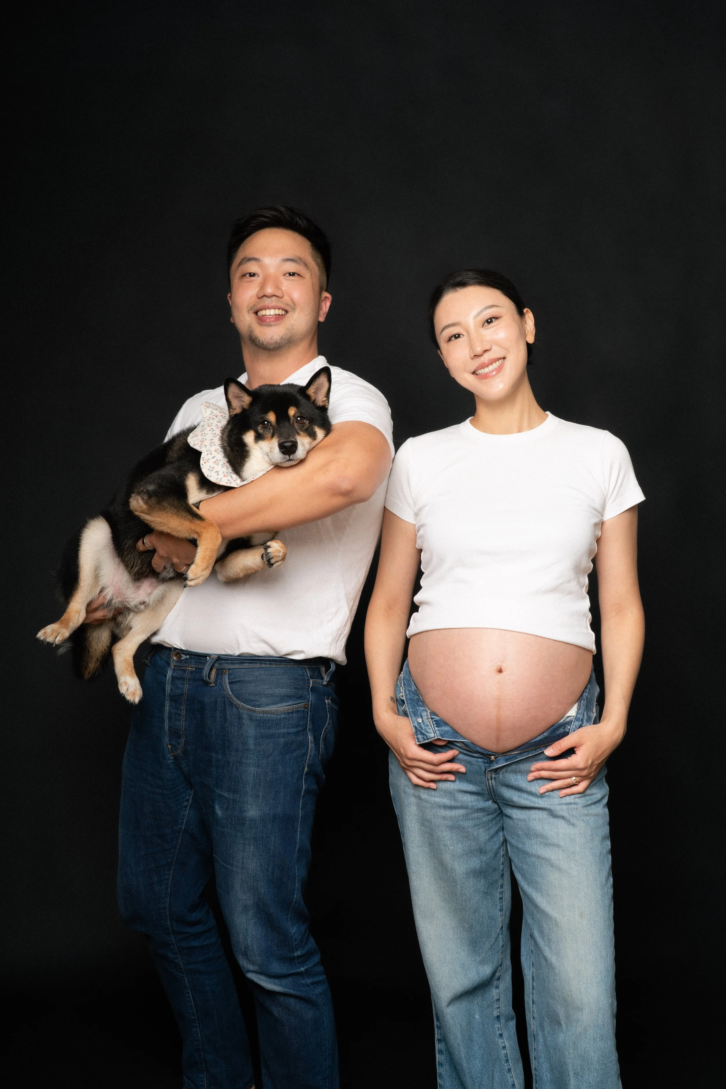Pregnant Cloris with husband Eric and Jesse the Shiba Inu in soft studio light, NYC maternity session