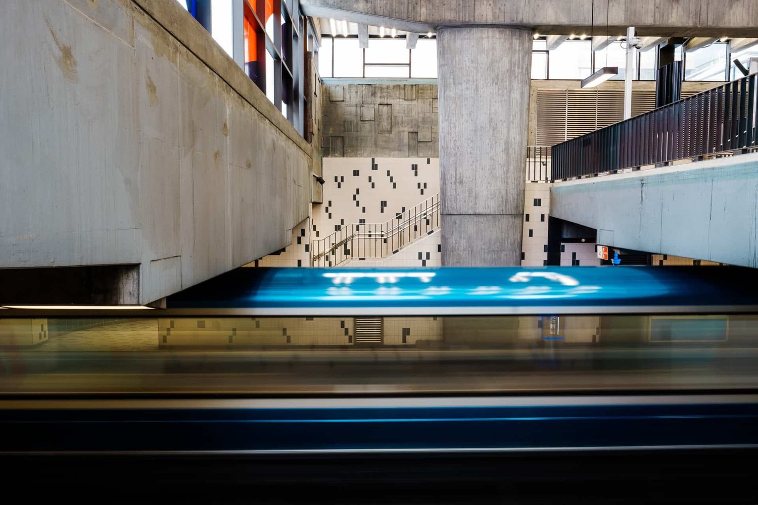 Métro Jarry — arched vault corridor, blurred blue train