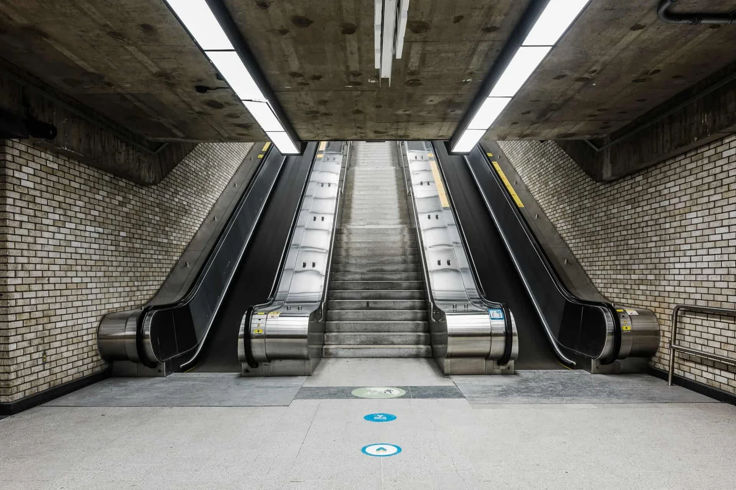 Place D'Armes — triple escalator symmetry, brick walls, concrete ceiling